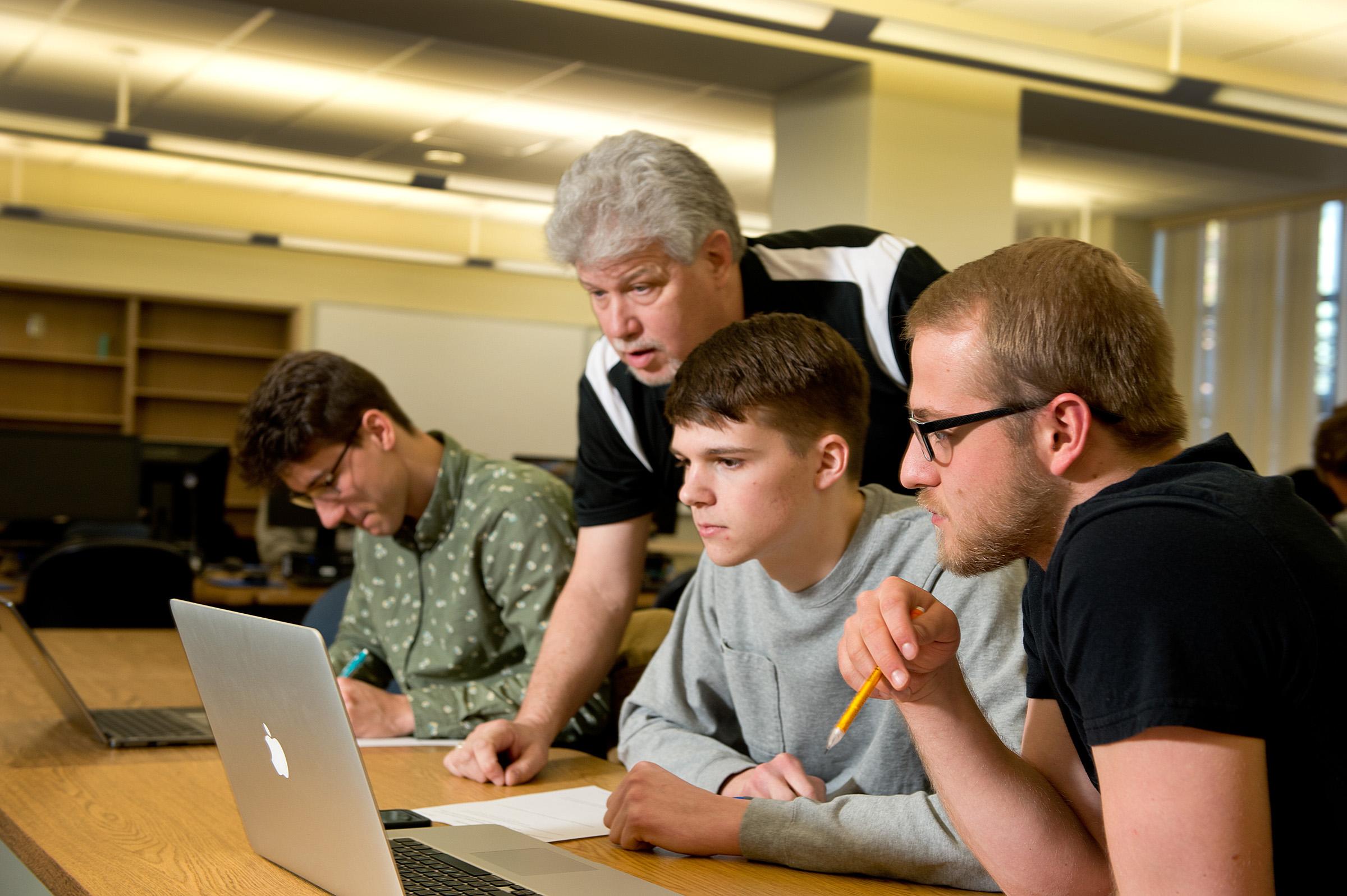 Students working on computer during class while professor is teaching