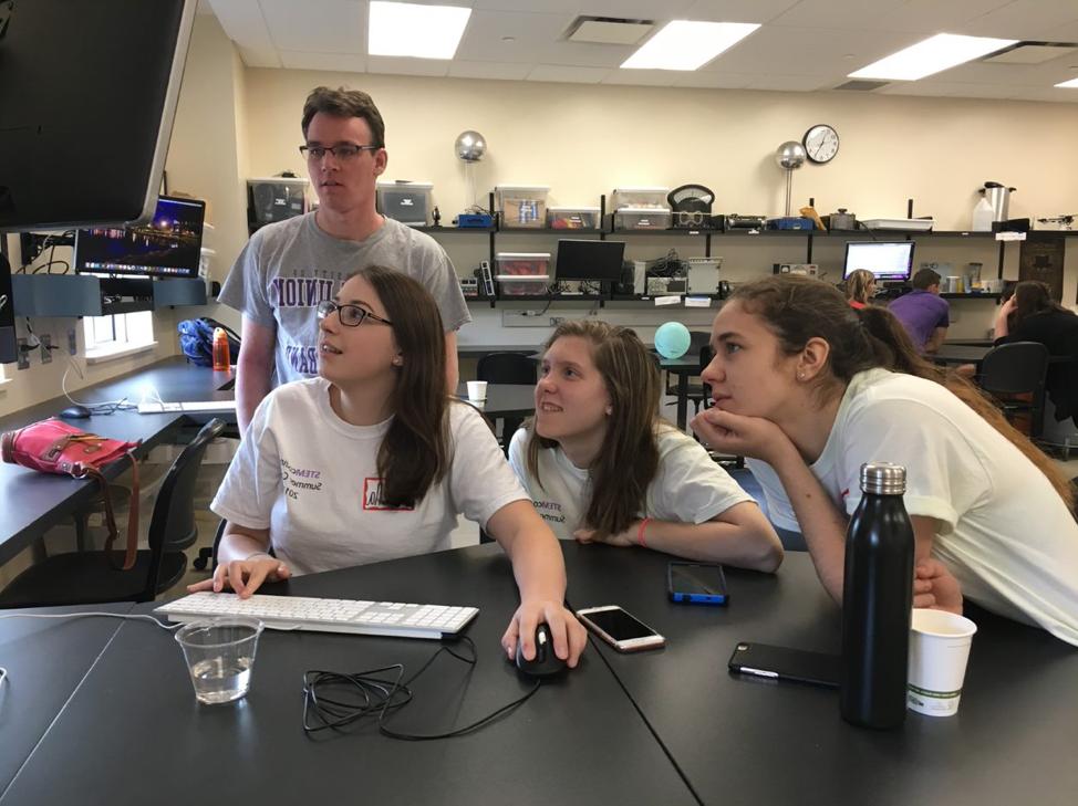 学生们在实验桌旁看电脑